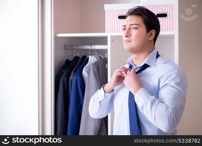 Young man businessman getting dressed for work