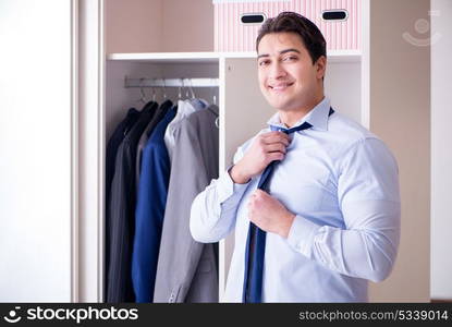 Young man businessman getting dressed for work