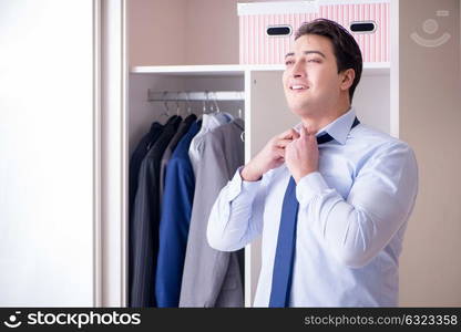 Young man businessman getting dressed for work