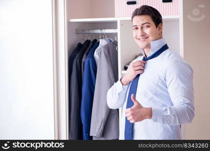 Young man businessman getting dressed for work