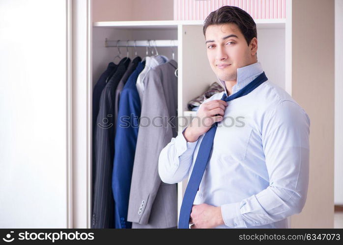 Young man businessman getting dressed for work