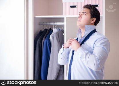 Young man businessman getting dressed for work