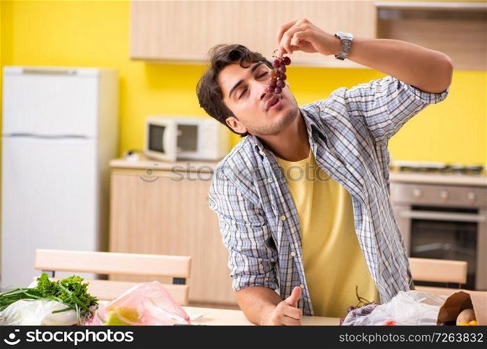Young man calculating expences for vegetables in kitchen . The young man calculating expences for vegetables in kitchen 