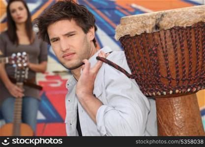 Young man carrying a djembe