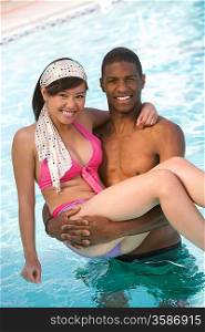 Young Man Carrying Young Woman in Swimming Pool, Portrait