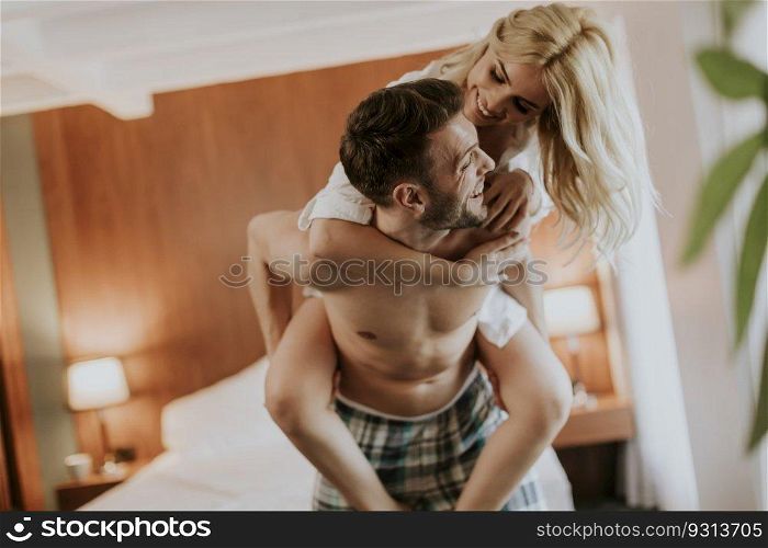 Young man carrying young woman oh his back and having fun