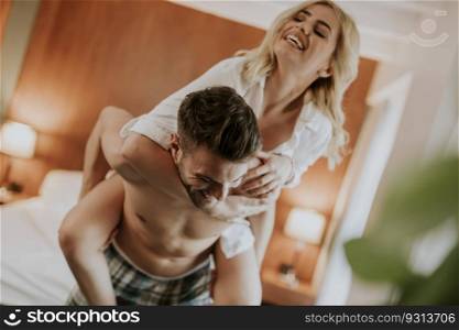 Young man carrying young woman oh his back and having fun