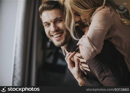 Young man carrying young woman on his back and having fun