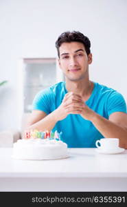 Young man celebrating birthday alone at home