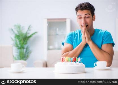 Young man celebrating birthday alone at home. The young man celebrating birthday alone at home