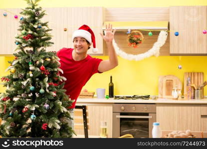 Young man celebrating Christmas in kitchen 