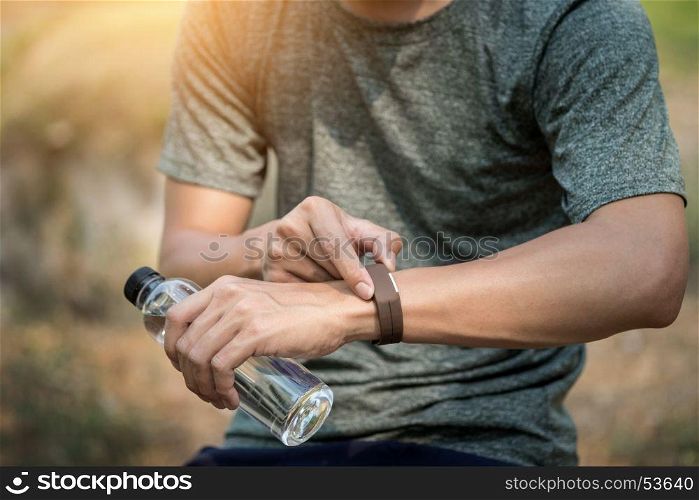 Young man checking time on his sports watch.