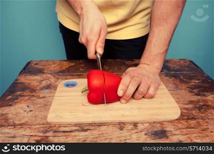 young man chopping a red pepper