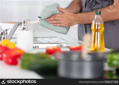 young man cleaning dishes in the kitchen