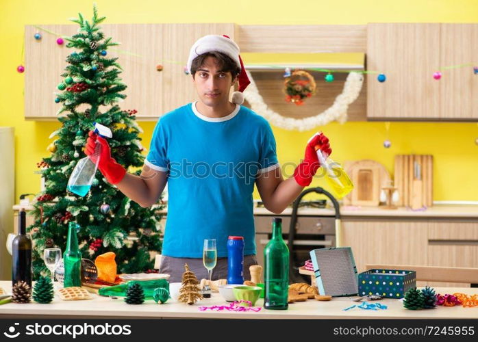 Young man cleaning kitchen after Christmas party 