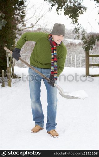 Young Man Clearing Snow From Drive