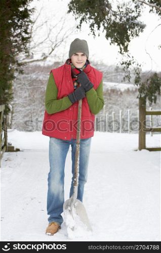 Young Man Clearing Snow From Drive