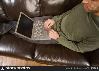 Young Man Computing on Couch
