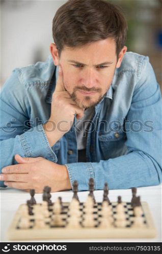 young man considering his next chess move