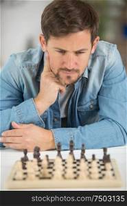 young man considering his next chess move