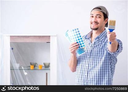 Young man contractor choosing color from rainbow 