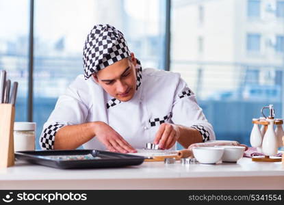 Young man cooking cookies in kitchen