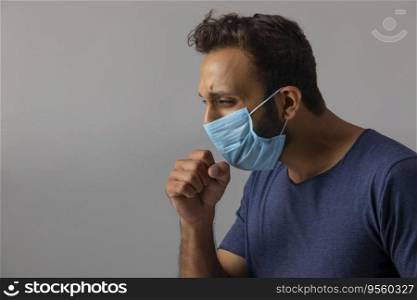 Young man coughing with his mask on