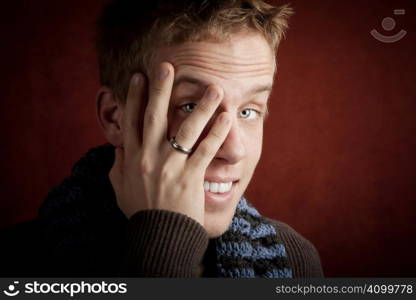 Young man covering face with his hand