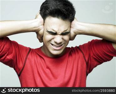 Young man covering his ears