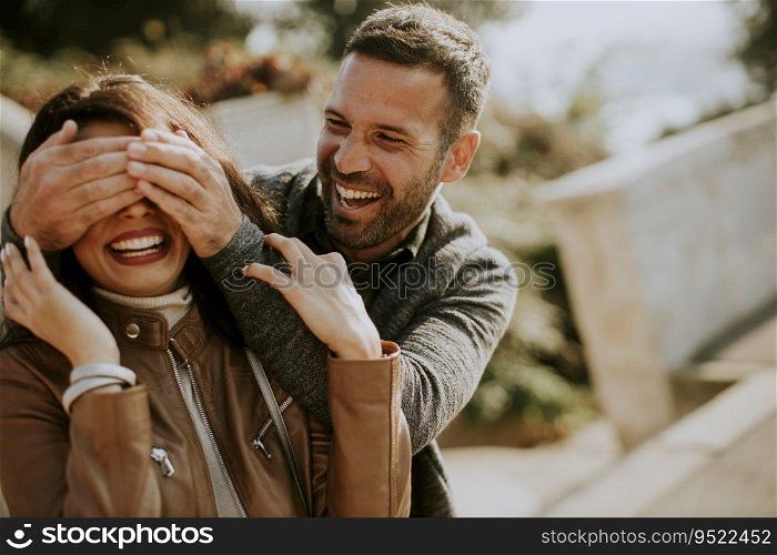 Young man covering the eyes of his girlfiend in the park