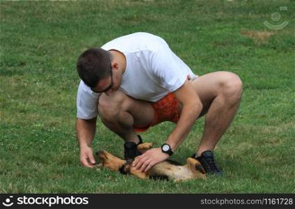 Young man cuddles sweet mongrel dog
