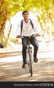 Young Man Cycling Along Street To Work
