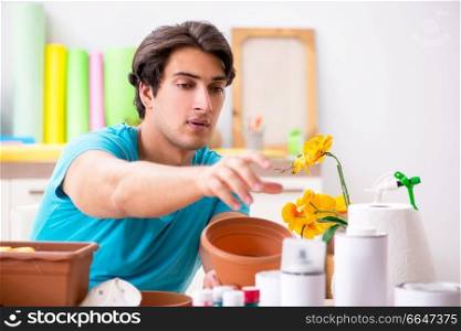 Young man decorating pottery in class