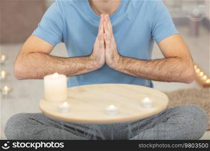 young man doing yoga and meditating at home