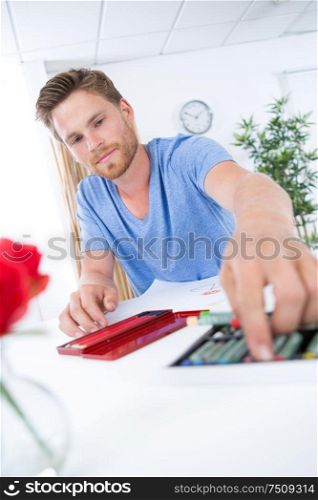 young man drawing in coloring book