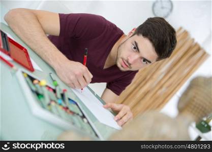 young man drawing pictures in studio