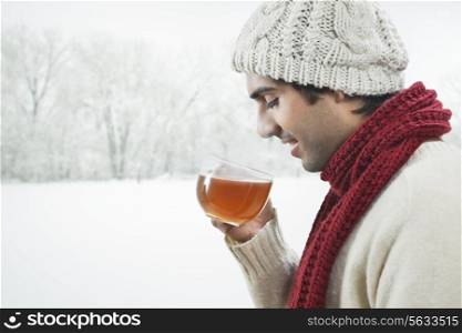Young man drinking black tea during winter