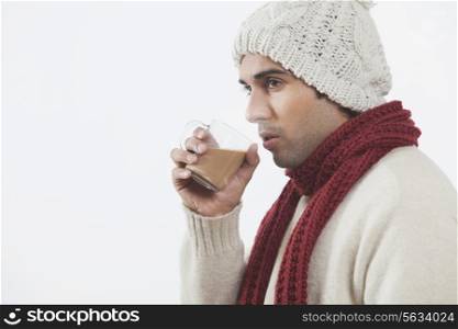 Young man drinking tea over white background
