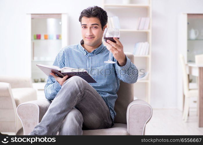 Young man drinking wine at home