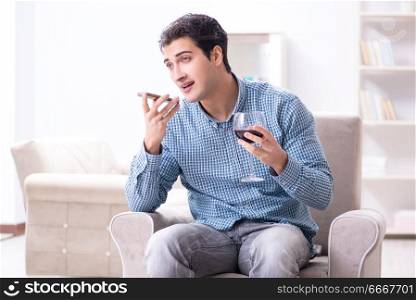 Young man drinking wine at home