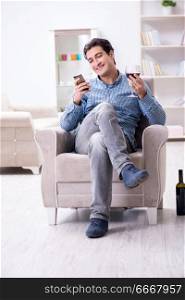 Young man drinking wine at home