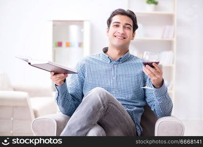 Young man drinking wine at home