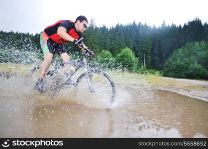 young man drive mountain bike over water river