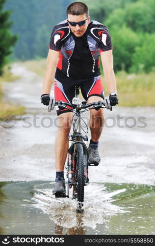 young man drive mountain bike over water river