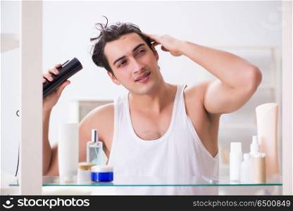 Young man drygin his hair in the morning