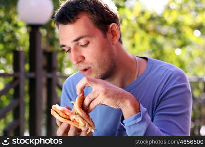 Young man eating burger in fast food