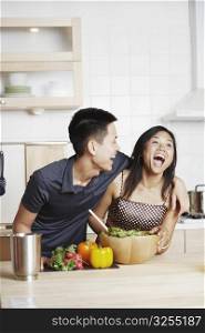 Young man embracing a young woman in the kitchen