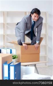 Young man employee with boxes in the office 