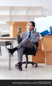 Young man employee with boxes in the office 