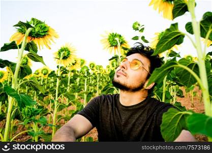 Young man enjoying the day in a field of sunflowers